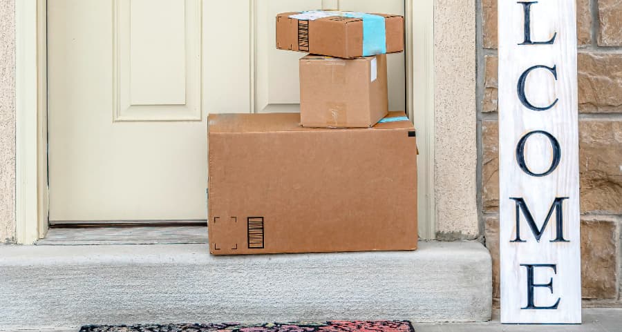 Boxes by the door of a residence with a welcome sign in The Woodlands